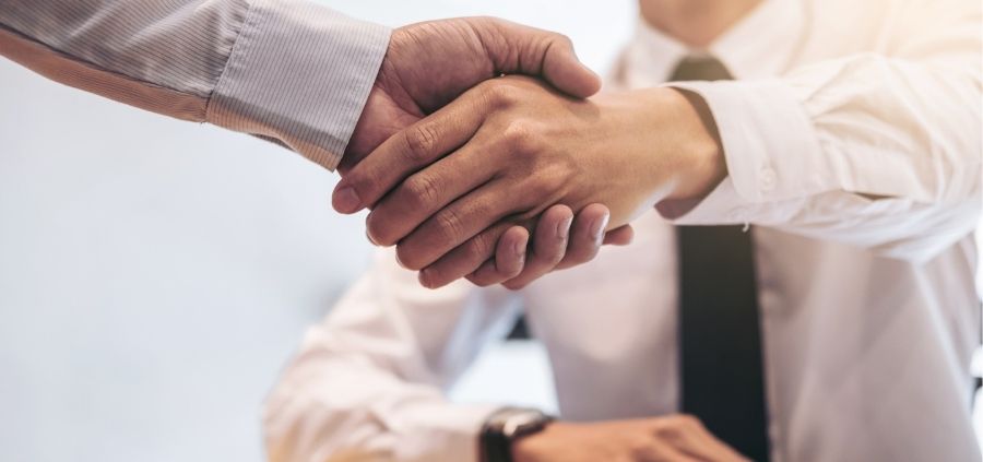 business men shake hands after running through important questions to ask when buying a business