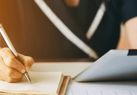 business person writing in notebook