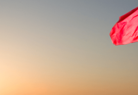 red flag with a sunset in the background