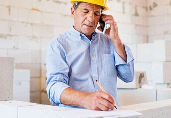 contractor on phone writing notes