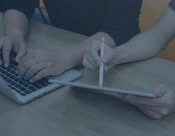 people reviewing tablet and laptop