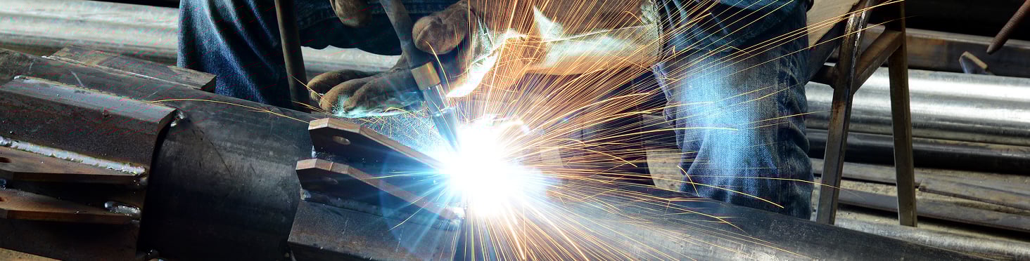 man using tool on pipe