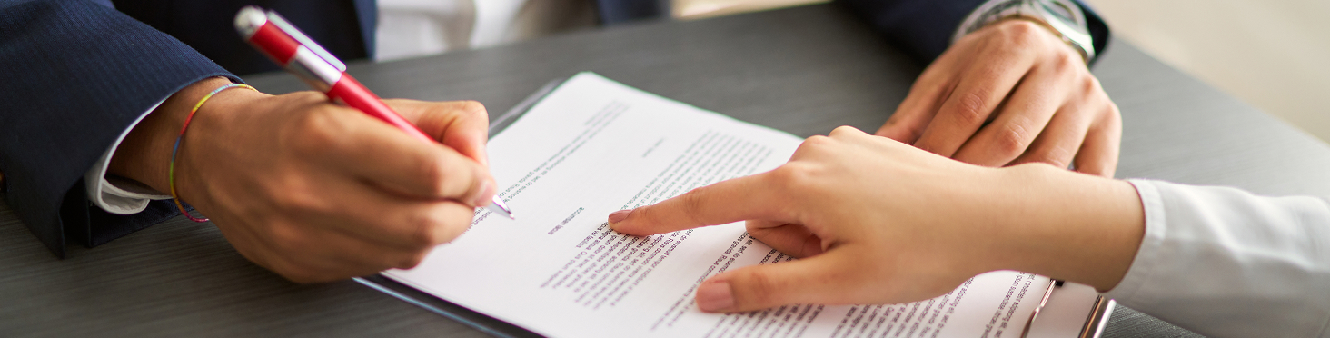woman showing client where to sign paperwork