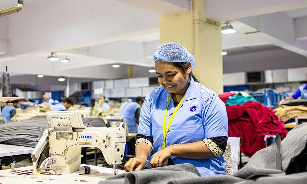 seamstress using sewing machine on towels