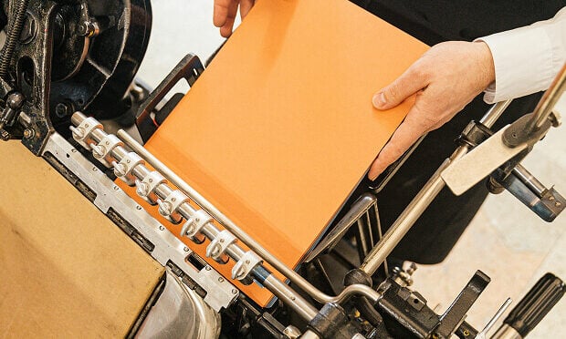 man lying book inside printing machine