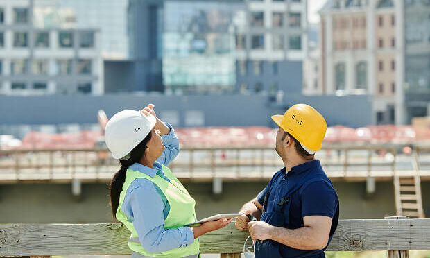 construction workers inspecting building overhead