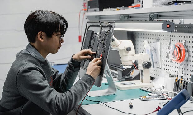man fixing hard drive of computer