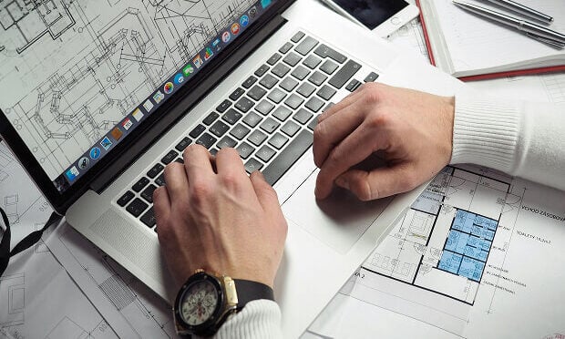man reviewing building layout design on computer