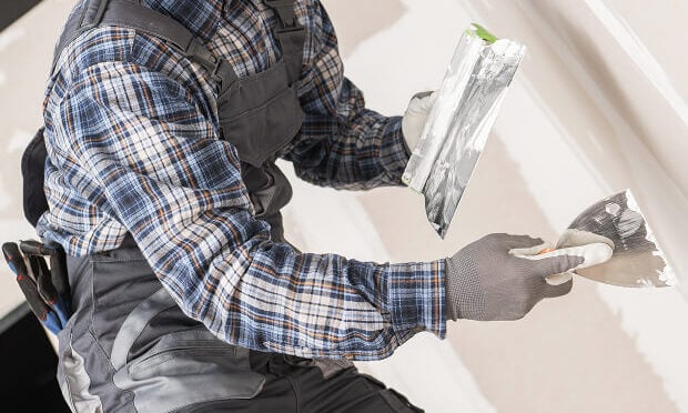 man applying drywall