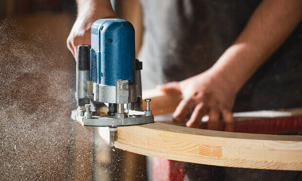 man sanding piece of wood