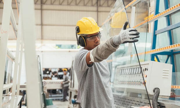 man carrying sheet of glass