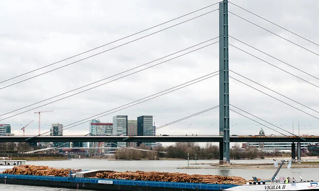freight vessel and boat in front of bridge