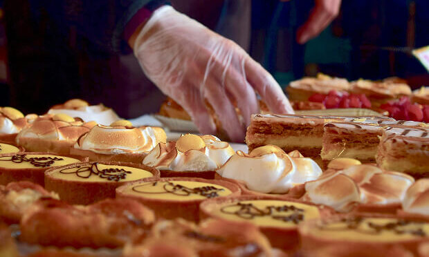 woman assembling rows of pastries