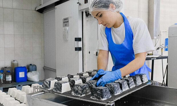 woman packaging frozen food containers inside manufacturing facility