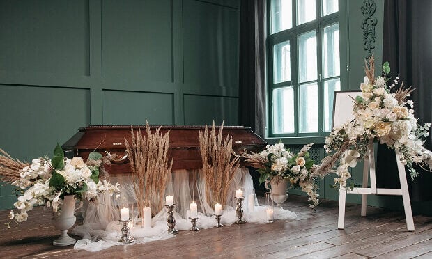 casket, flowers, and candles inside funeral home