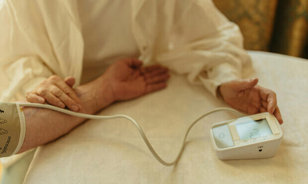 home health care aid checking patient's blood pressure