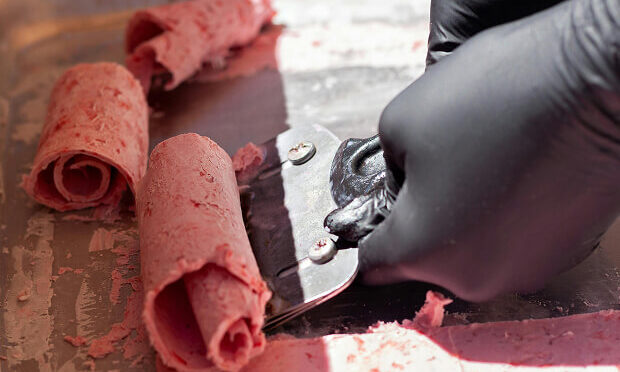 worker scooping rolled ice cream