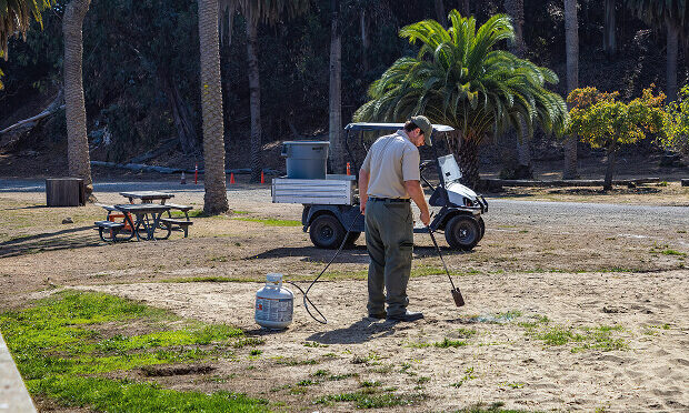 man spraying chemicals on damaged lawn