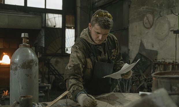 man reviewing paperwork for metal project