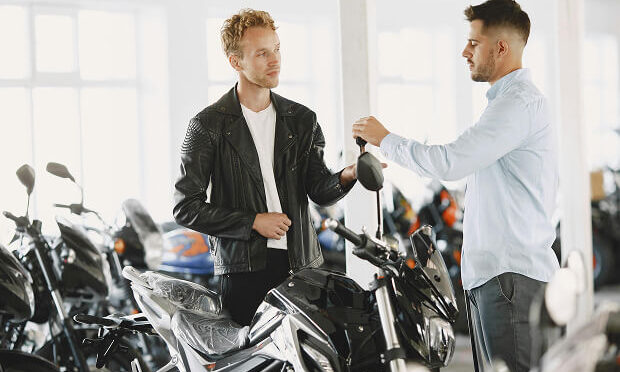 sales man handing customer keys for motorcycle