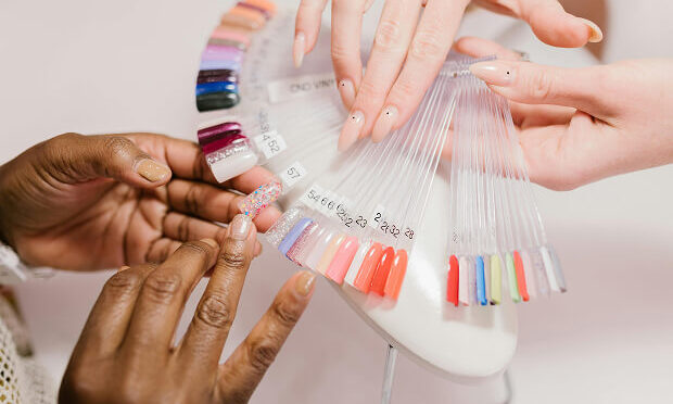 nail tech showing woman nail color swatch