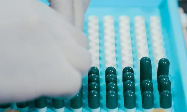 pharmaceutical worker stacking medicine in container
