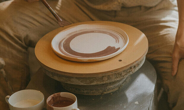 man painting a plate