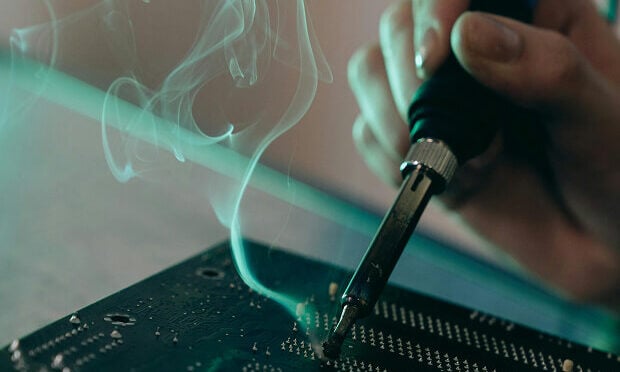 man using instrument on printed circuit