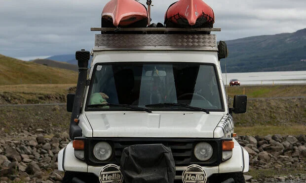 white vehicle with canoes on top