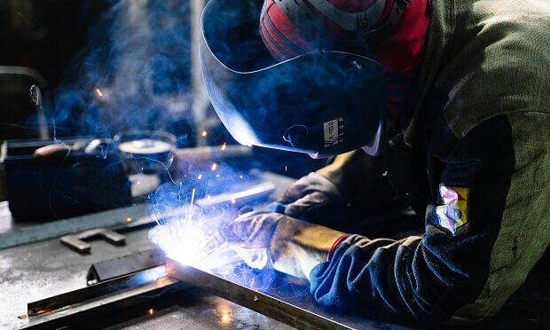man using tool on sheet metal