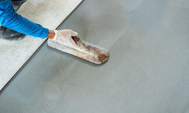 worker smoothing freshly laid tile