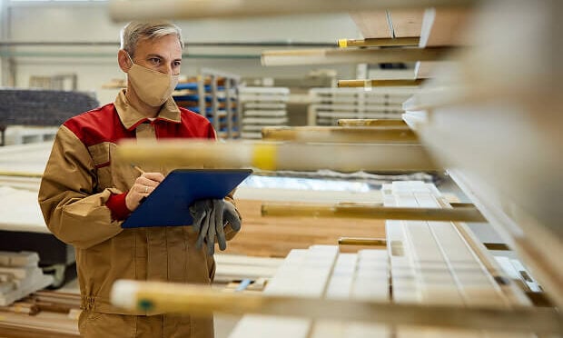 man inspecting wood pallets